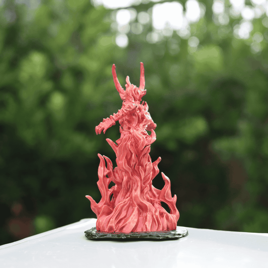 Back view of Fire Queen miniature showing detailed flame textures and horned silhouette, standing on black base.