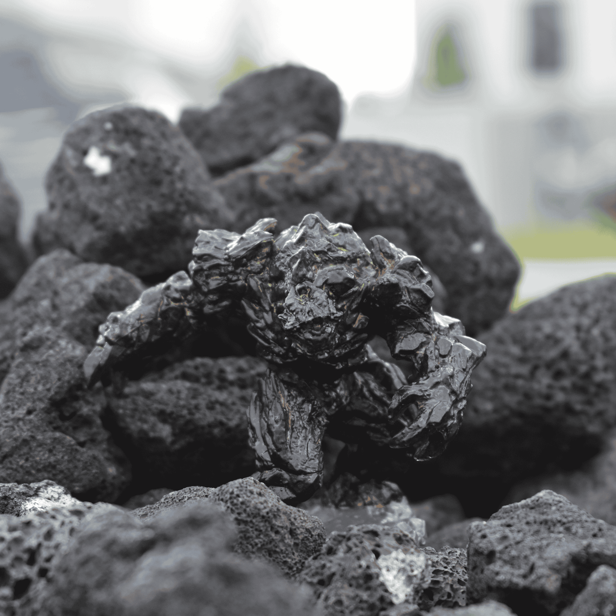 Black Magma Golem miniature crouched among lava rocks, emphasizing its detailed stone body and glowing red fissures.