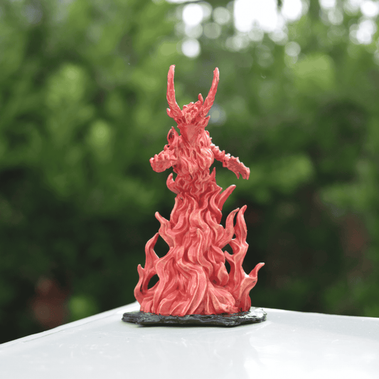 Fantasy Fire Queen miniature with fiery sculpted base and extended arm, displayed against a soft green natural backdrop.